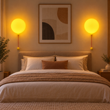 Two wall-mounted balloon night lights arranged beside a bed
